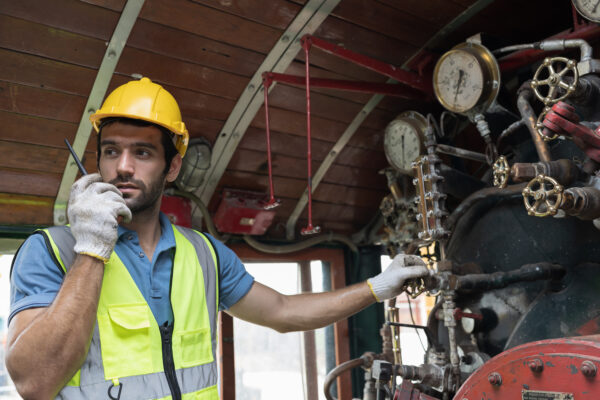 Male plumber maintenance water pipes in water pumping station. M